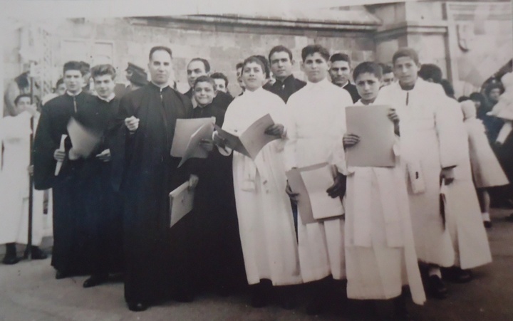 Στη φωτογραφία διακρίνονται ο Μιχάλης Σαρρής, στ’ αριστερά του με το άσπρο ράσο, ο Θ. Καραναστάσης και μεταξύ άλλων ο Βασίλης Έλενας, ο Ηλίας Ελιαδάκης, ο Νίκος Σταυριανός