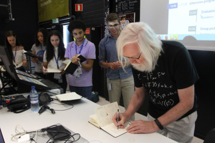 Ο καθηγητής Φυσικής και μέλος του Royal Society, John Ellis, υπογράφοντας ένα αυτόγραφο στον Νικόλα (ακριβώς δίπλα του) μετά το πέρας της διάλεξής του με θέμα “Beyond the Standard Model”