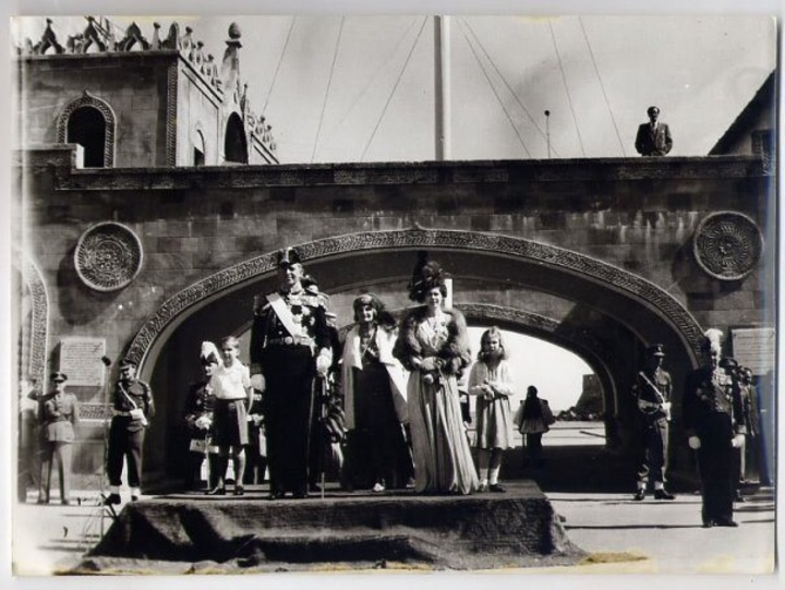 Οι βασιλείς Παύλος και Φρειδερίκη με τον διάδοχο Κωνσταντίνο και τις πριγκίπισσες Σοφία και Ειρήνη παρακολουθούν  τη στρατιωτική παρέλαση. Διακρίνεται ανάμεσα στο βασιλικό ζεύγος η πριγκίπισσα Μαρία Βοναπάρτη 