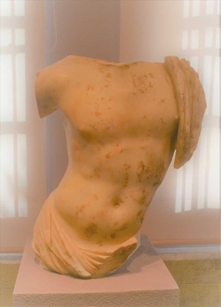 Γυμνός κορμός ανδρικού αγάλματος, με ιμάτιο γύρω από τη μέση και τον αριστερό ώμο.  Βρέθηκε στο ρωμαϊκό Ωδείο.  Γύρω στο 180/170 π.Χ.