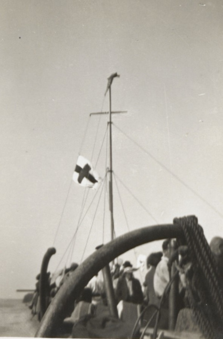 Οι επιβάτες υψώνουν μια λευκή σημαία με τον Ερυθρό Σταυρό πάνω από το Pentcho μετά  το ναυάγιο του