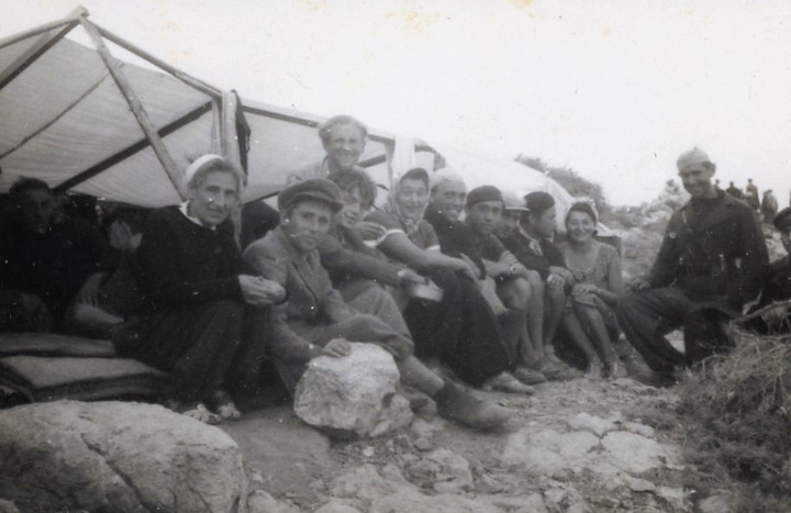 Εβραίοι πρόσφυγες από το ναυάγιο Πέντσο κάθονται δίπλα σε ένα αυτοσχέδιο καταφύγιο, πιθανόν με τους Ιταλούς διασώστες τους,  στο νησί Καμηλονήσι. Αριστερά κάθεται η Stefanie Fellner