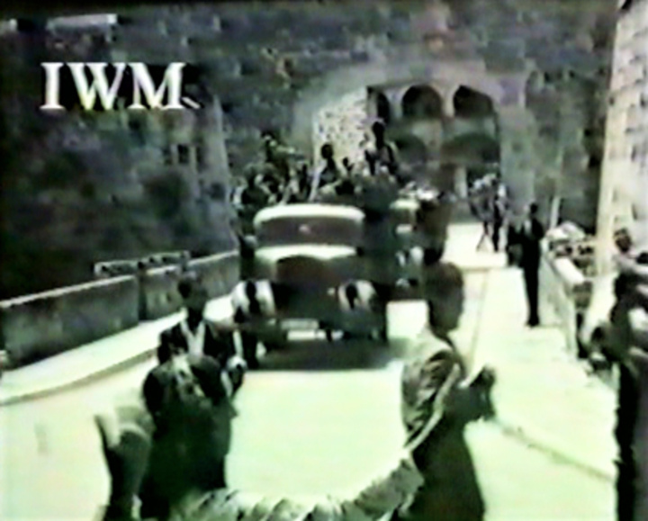 9 Μαΐου1945. Οι Συμμαχικές Δυνάμεις διέρχονται  από την πύλη Μάριο Λάγκο στη νέα πόλη της Ρόδου.  Κατεύθυνση το Αλμπέργκο ντε λε Ρόζε