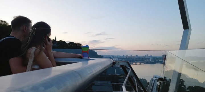 Ένα ερωτευμένο ζευγάρι νεαρών χαλαρώνει στη γυάλινη γέφυρα με φόντο τον Δνείπερο.